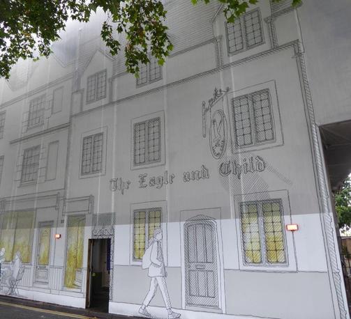 Scaffolding awning with a hand-pencilled drawing of an old pub upon it, with the words The Eagle and Child.