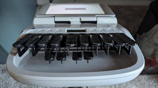 A white stenographery machine.