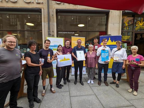 Mitglieder der Bündnis Dresden fair.wandeln und Bildungsbürgermeister Jan Donhauser feiern gemeinsam die Titelerneuerung: Dresden bleibt Fairtrade Town