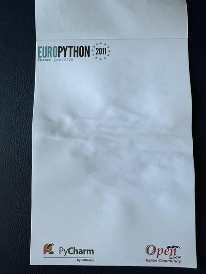An old notebook saying:

EUROPYTHON 2011
Firenze – June 20 / 26

And “PyCharm by JetBrains” and “OpenERP Italian Community” at the bottom 