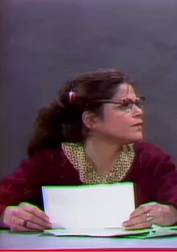 Video clip of Emily Litella, a light skinned femme presenting woman wearing a shawl and glasses,played by Gilda Radner
(Audience laughter in background)
Elmily; “I’m sorry…Never Mind.”
