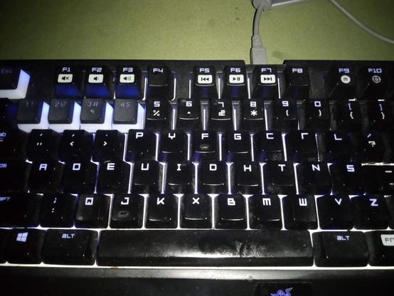 Glowing keyboard with strange keys in Dvorak.