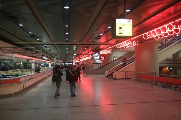 Hall of a congress center with neon lights on the right.