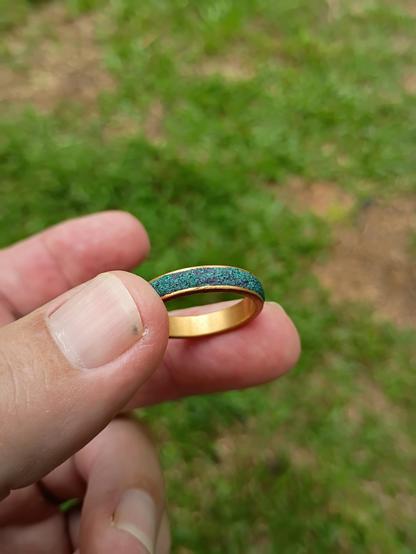 Gold ring with unknown green material around it