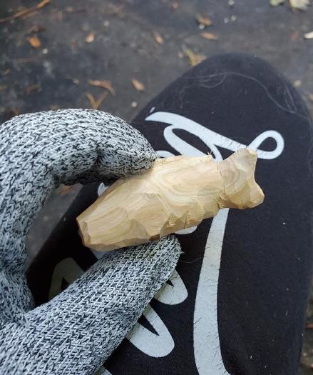 crude redwood fishy held in gloved fingers