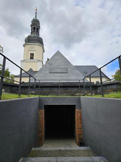 Außenansicht der restaurierten Begräbnispyramide der Familie von Eberstein in Leipzig-Schönefeld mit glattem schwarzen Stein.