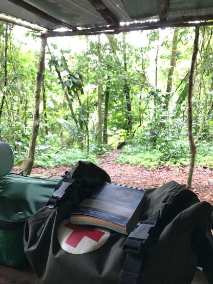 A picture of the CoROM Field Guide sitting on top of a medical pack with jungle in the background.