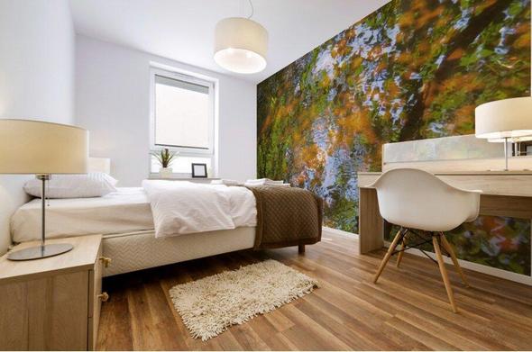 A large, impressionistic mural of a pond with green and orange Autumn leaves and blue water on a bedroom wall.
