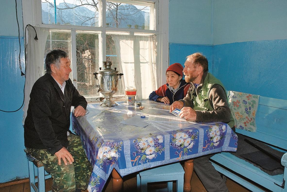A researcher talks to the Buryats at a kitchen table.