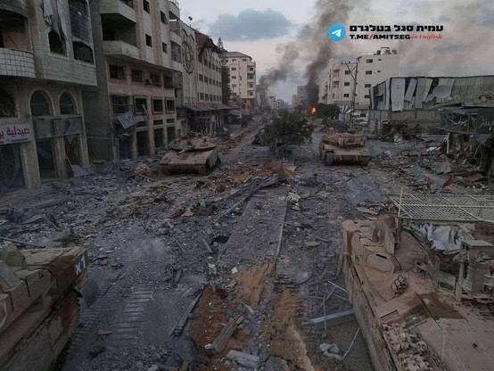 Israeli tanks on empty Gaza City street, once bustling with life.