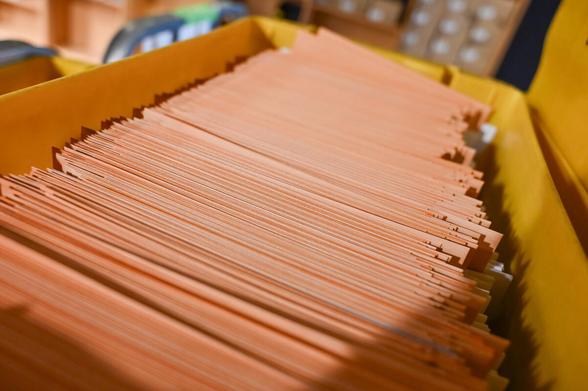 Gelbe Box voll mit orangefarbenen Umschlägen. Die Briefwahlpost.