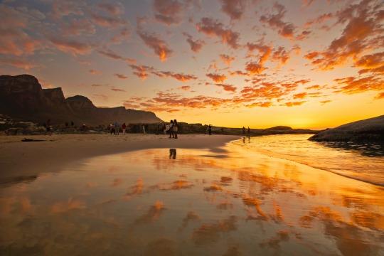 Pink clouds reflecting in calm water.