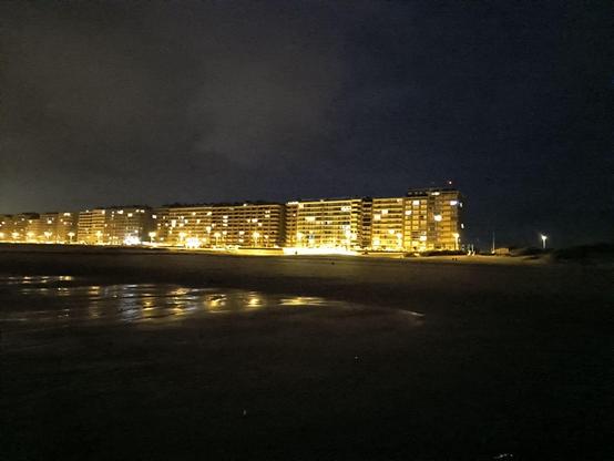 Auf dem Bild zu sehen sind die beleuchteten Fenster der Häuser Strandfassade in Middelkerke die aus 8-10 stöckigen, aneinandergebauten Häuserblöcken besteht.