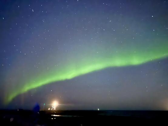 A line of green aurora goes over Grótta lighthouse