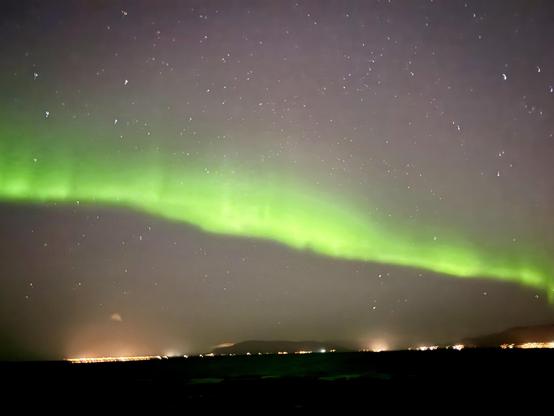 A line of green aurora over the ocean