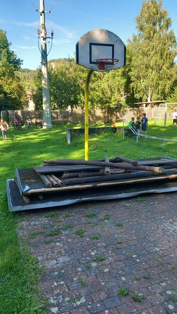 Ein Basketballkorb ist von Abrissholz blockiert.