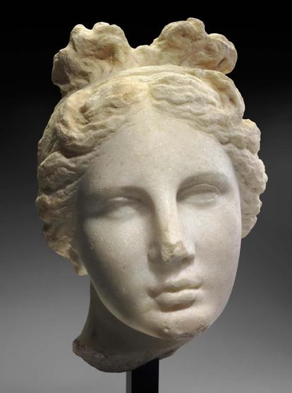 Marble head of Aphrodite with a top-bow hairstyle that Apollon also often wears in artwork.