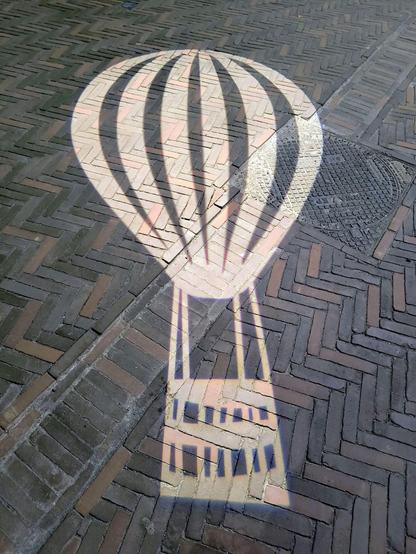 Zu sehen ist die Silhouette eines Heißluftballon die auf das Pflaster der Marktplatz gesprüht wurde, anlässlich des vergangenen Friedensfest, dass auch ein Ballonfest ist.