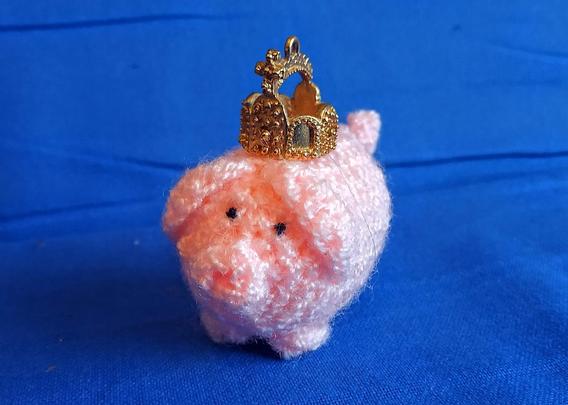 Ein haekelschwein trägt die Reichskrone.