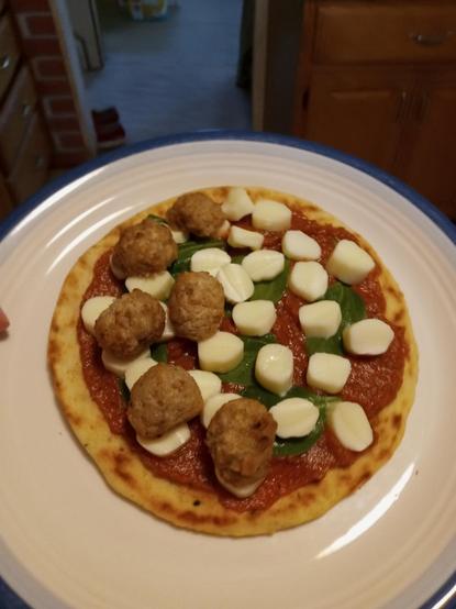 Our final photo is of the pizza assembled, but not yet cooked. The ingredients are roughly evenly spaced across the naan. Except for the meatballs, which are only on the left half.