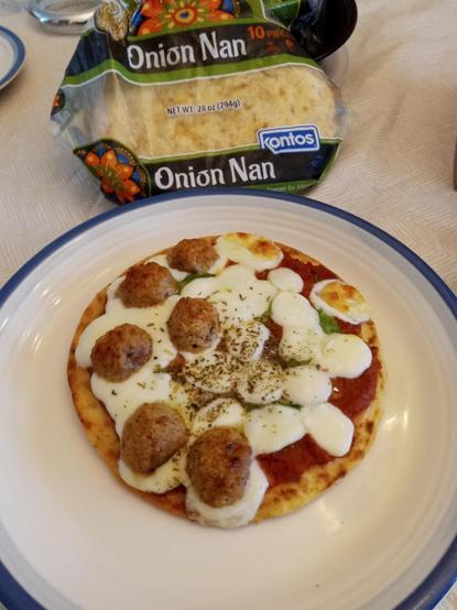 Moving backward in time, a photo from before the pizza was sliced. Behind the pizza is a bag labeled "Onion Nan".