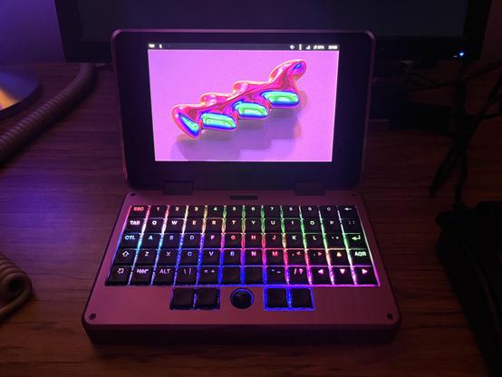 A small purple laptop, with a rainbow keyboard.