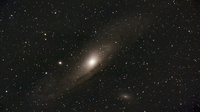 M31 Andromeda, M32 and M110 - telescope processed image.  M31 (Andromeda) is the largest spiral galaxy in our Local Group. M32 and M110 are its dwarf elliptical satellite galaxies. They're all approaching the Milky Way. 