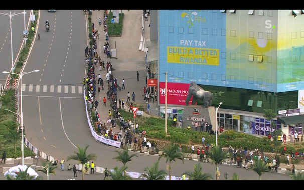 Beeld tijdens het WK Wielrijden in Rwanda.
Op de gevel van een winkelcentrum staat een mededing van de overheid:
Pay Tax
Build a better Rwanda
