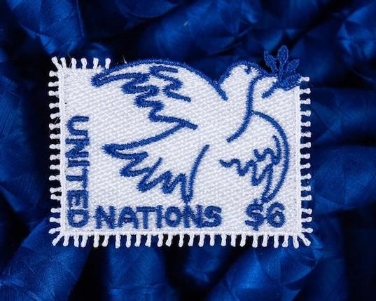 An embroidered stamp in the shape of a dove.