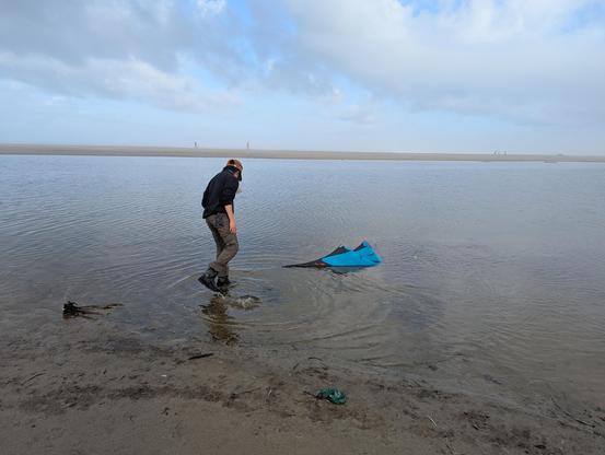 Cardin Nguyen fishing his Lam Hoac sport kite out of the water in Lincoln City, Oregon in the morning of the fall kite festival