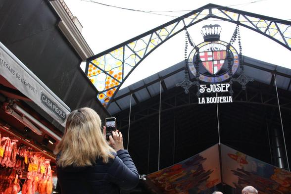 Una dona fotografia l'entrada del mercat (3Cat)