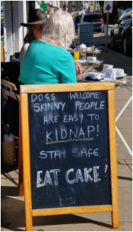 Charkboard at cafe: Skinny People are easy to kidnap. Stay safe! Eat cake. 