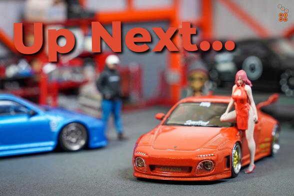 An Old & New 997, Red metallic by Tarmac Works in 1:64 scale with 1:64 figures on AREA 164