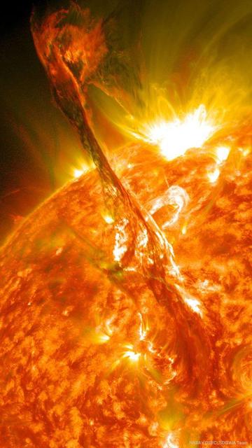 Portrait image of a massive solar filament looping up from the surface of the Sun as it snapped apart, releasing a massive amount of energy.