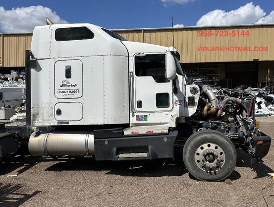 Imagen de un camión Kenworth T600 modelo 2007, en color blanco, cabina larga con puertas robustas, espejos laterales grandes, tanque de diesel, faldones aerodinámicos y ruedas resistentes, estacionado en un entorno industrial propio del norte de México, ideal para transporte de carga y flotas de larga distancia.

