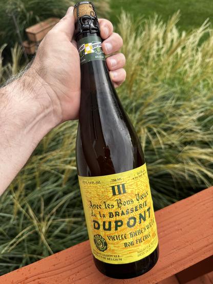 “Avec les Bon Voeux de la Brasserie DUPONT.“ A corked 25.4oz bottle of beer.