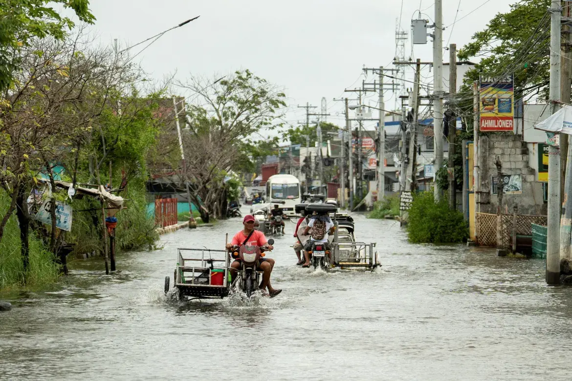 Motorists wade through a flooded road in Apalit after super typhoon Ragasa.