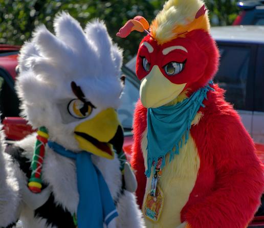 Im Vordergrund ein Orni Fursuiter, im Hintergrund ein roter Vogel Fursuiter