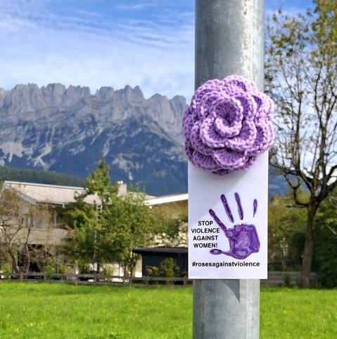 a purple knitted rose in ellmau, austria. stop violence agaist women