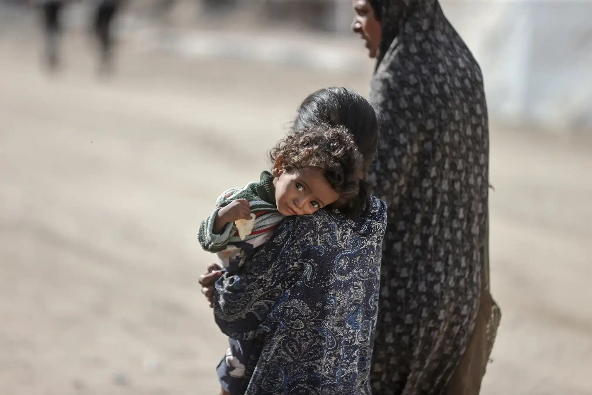 A woman with nothing but her two children, a girl carries a child.