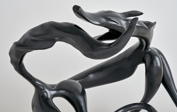 Closeup of Abstract sculpture of a dog spinning to catch its tail, evocative of the movement of this playful moment.