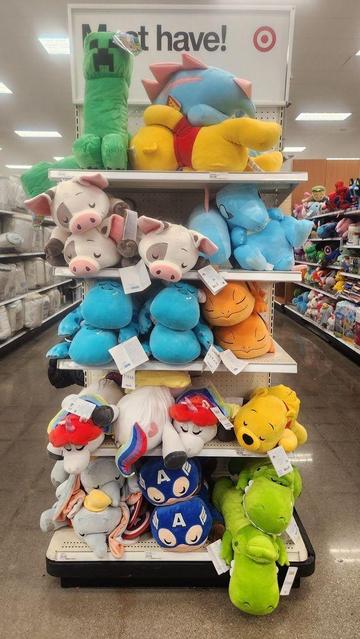 Photograph: Character plush pillows on display at a local Target store.
Photographer: daithiensu (self).
Link:
<https://www.target.com/p/minecraft-creeper-14-34-x7-34-kids-39-pillow-buddy-green/-/A-52056751>;
<https://www.target.com/p/pokemon-18-34-sleeping-plush-totodile/-/A-91959747>;
<https://www.target.com/p/moana-pua-kids-39-cuddleez/-/A-82097178>;
<https://www.target.com/p/monsters-inc-large-plush-sulley-cuddle-pillow-disney-store/-/A-79380138>;
<https://www.target.com/p/pokemon-charmander-sleeping-kids-39-plush-buddy/-/A-79833009>;
<https://www.target.com/p/disney-unicorn-kids-39-cuddleez-plush/-/A-93973248>;
<https://www.target.com/p/winnie-the-pooh-kids-39-cuddleez/-/A-82097177>;
<https://www.target.com/p/cuddleez-dumbo-kids-39-pillow/-/A-85238672>;
<https://www.target.com/p/disney-toy-story-rex-kids-39-cuddleez-pillow-disney-store/-/A-79643705>.