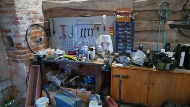 Werkzeugbank mit zahlreichen Werkzeugen am Brett.