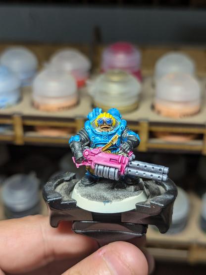 A painted dwarf miniature with a pink heavy stubber.