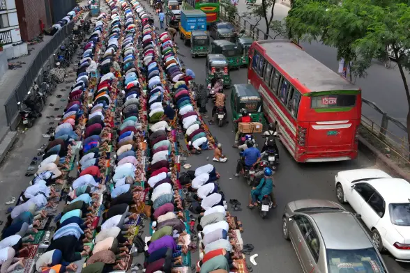 Muslim worshippers perform Friday prayers on a busy street. 
