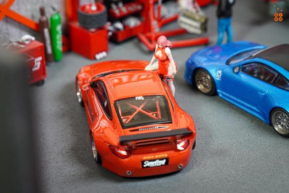 A top up view of Old & New 997 Red Metallic by Tarmac Works in 1:64 scale with 1:64 figure on AREA 164.