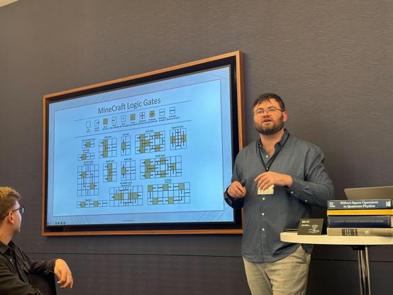 I stand in front of a slide depecting how one can build all of the classical logic gates from redstone in the videogame Minecraft. The same can be done for quantum gates out of individual atoms.