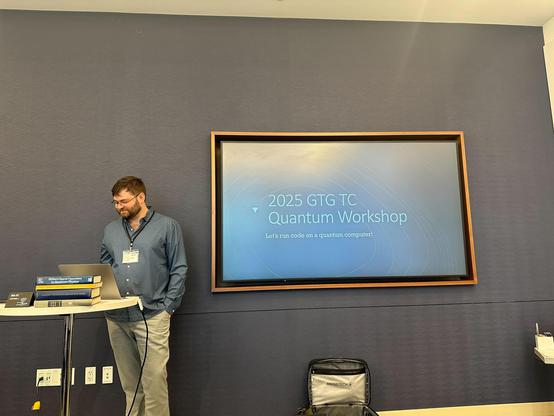 I stand in front of my title slide: 2025 GTG TC Quantum Workshop: Let's run code on a quantum computer!