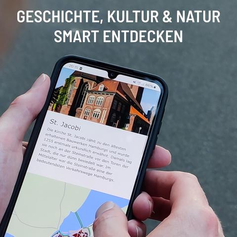 Zwei Hände halten ein Smartphone - dort sieht man einen Entdeckerpfad: oben ein Foto von einer Backsteinkirche, ein Text zu "St. Jacobi" und den Ausschnitt einer Karte. Der Hintergrund ist grau. Darauf der Schriftzug: Geschichte, Kultur & Natur smart entdecken