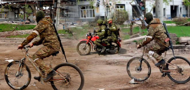 nazi russian soldiers on bikes overtaking two soldiers on motorbike in occupied Ukraine.
(Image: screenshot from Kanal13)